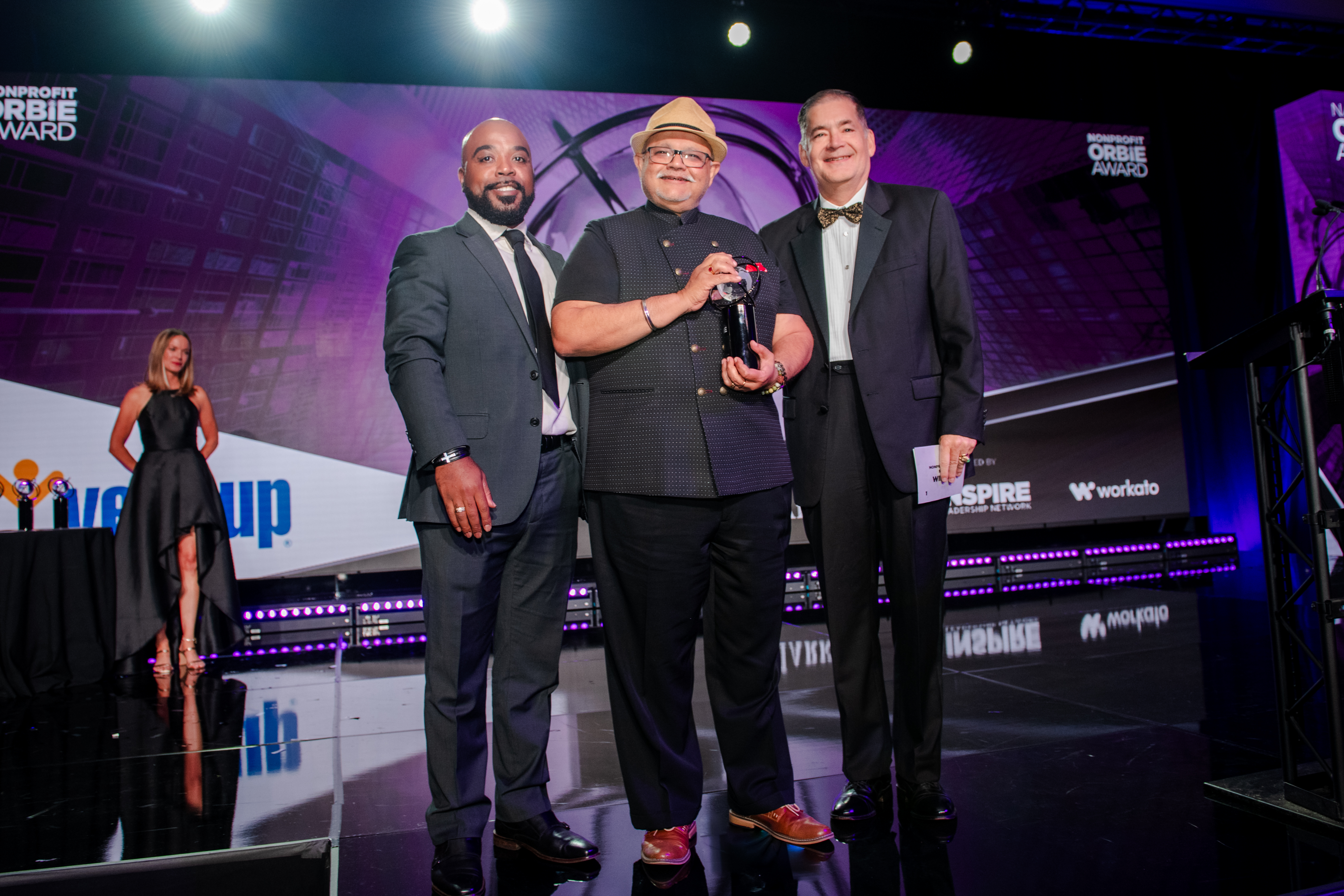 technology leader receiving ORBIE award, flanked on left and right by other technology leaders